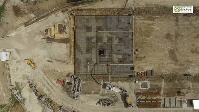 Aerial view of a new home's slab foundation being formed on a residential lot.