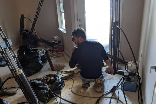 Quality Foundation Repair Austin team member running pier equipment during an interior repair.