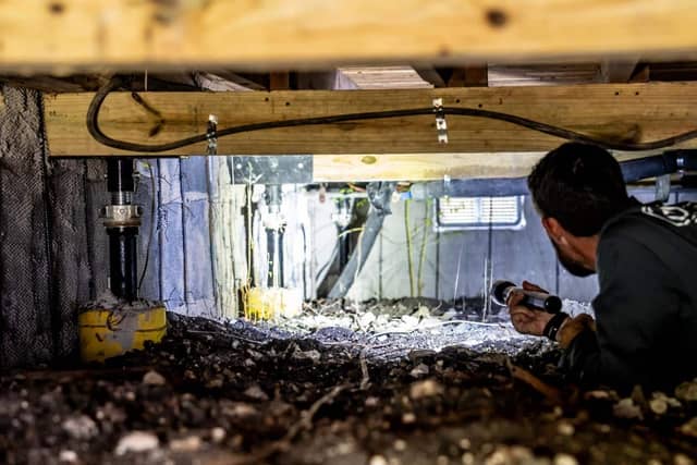 Quality Foundation Repair Austin technician inspecting a crawl space supported on Adjust-A-Piers.