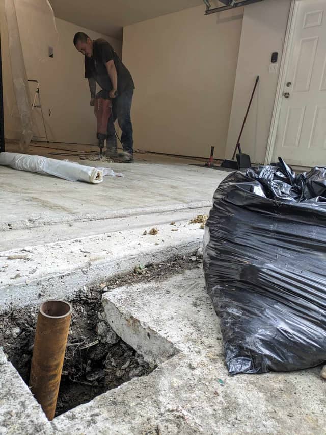 Quality Foundation Repair Austin worker operating a jackhammer to excavate a concrete floor for crawl space expansion.