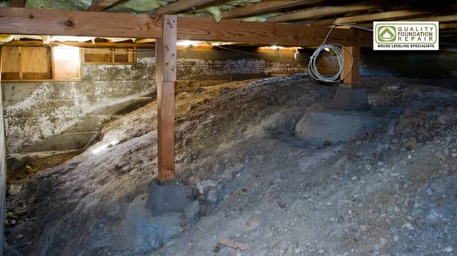Quality Foundation Repair Austin inspecting sagging crawl space with exposed soil and moisture damage.