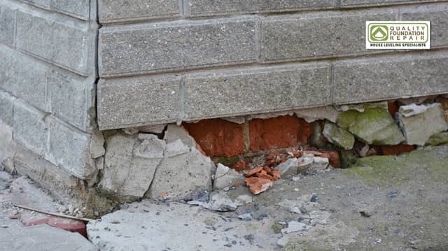 Quality Foundation Repair Austin inspecting severe cracked block foundation with crumbling concrete and exposed brick on an e