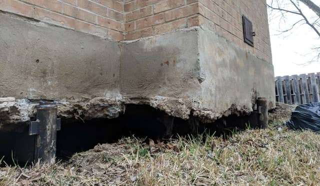 Quality Foundation Repair Austin inspecting crumbling foundation wall with exposed piers due to severe deterioration.