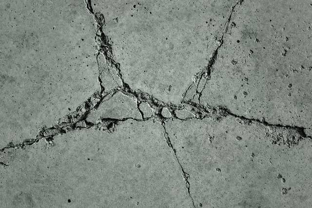 Quality Foundation Repair Austin inspecting severe cracks in a concrete foundation slab.