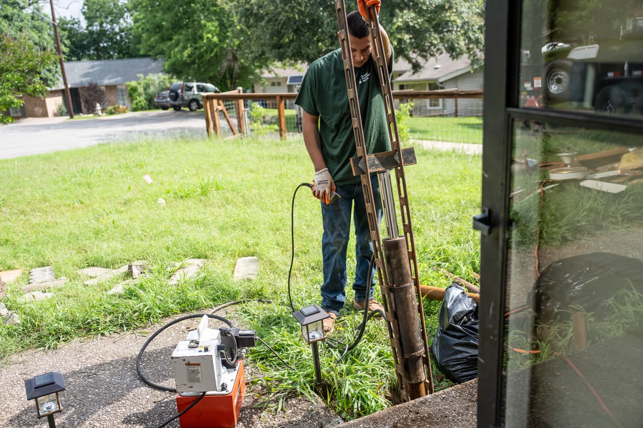 Quality Foundation Repair Austin technician operating hydraulic equipment for steel push pier installation.