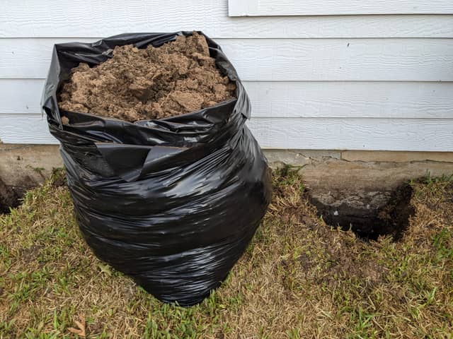 Quality Foundation Repair Austin showing excavated soil next to a residential foundation for repair work.